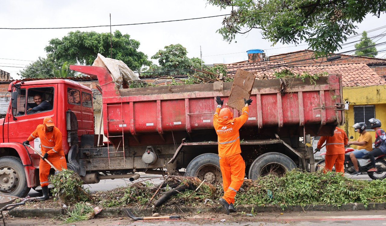 homens executando serviço de limpeza e colocando entulhos num caminhão